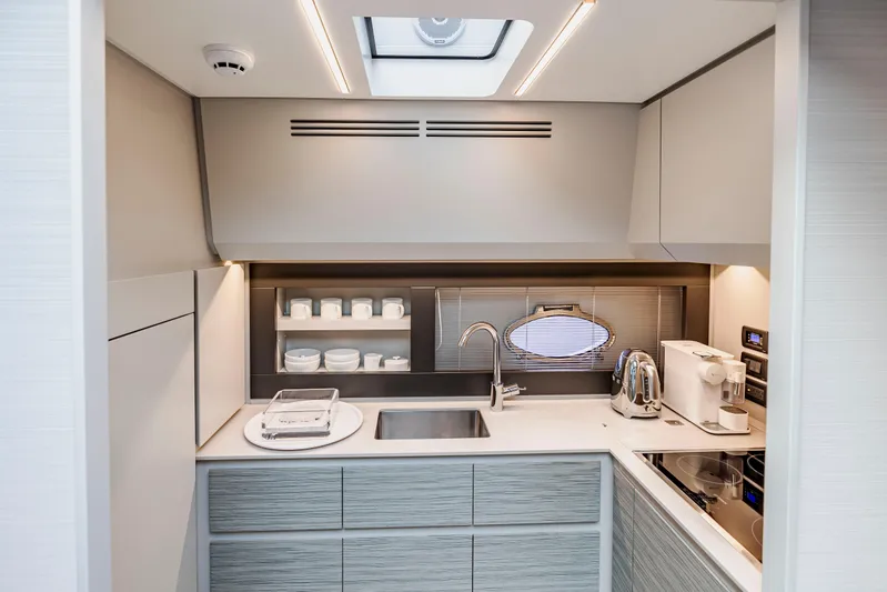 Sea Suite Yacht Photos Pics Modern kitchen interior on 2021 Pershing 62 yacht, featuring sleek cabinetry and appliances.