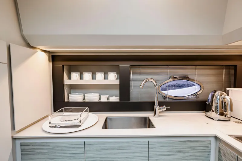 Sea Suite Yacht Photos Pics Modern kitchen interior on 2021 Pershing 62 yacht with sleek design and stainless steel fixtures.