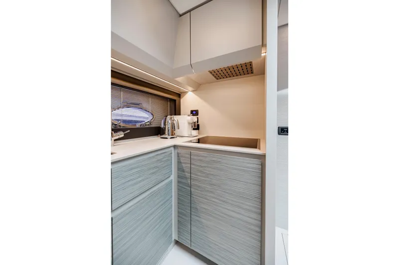 Sea Suite Yacht Photos Pics Modern kitchen interior on 2021 Pershing 62 yacht, featuring sleek cabinetry and appliances.