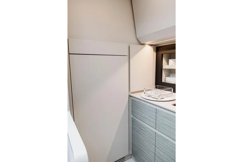 Sea Suite Yacht Photos Pics Modern kitchen interior of 2021 Pershing 62 yacht, featuring sleek cabinetry and lighting.