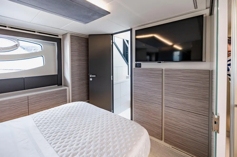 Sea Suite Yacht Photos Pics Luxurious bedroom interior of 2021 Pershing 62 yacht with modern design and TV.