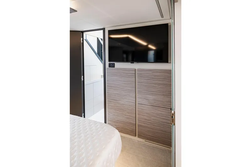 Sea Suite Yacht Photos Pics Modern interior of 2021 Pershing 62 yacht with TV and wood paneling.