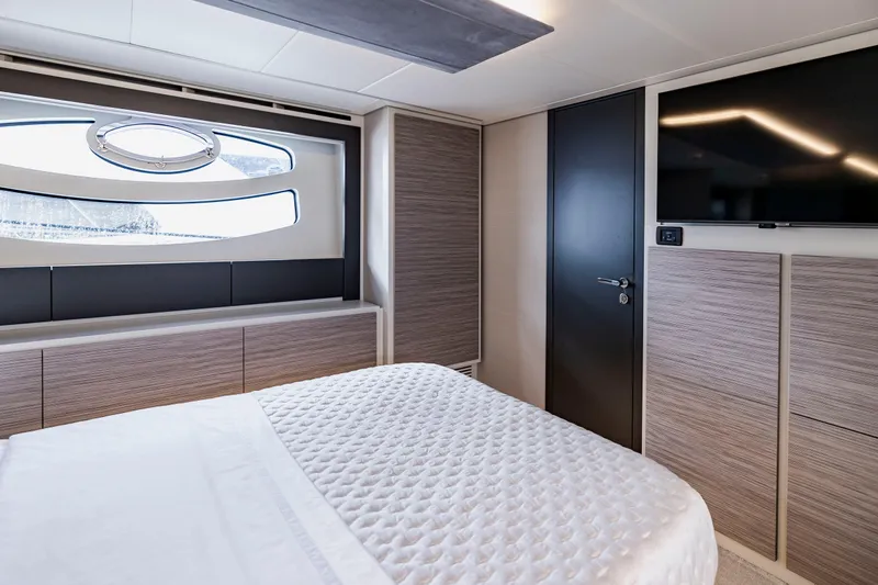 Sea Suite Yacht Photos Pics Luxurious bedroom interior of 2021 Pershing 62 yacht with modern design and large window.