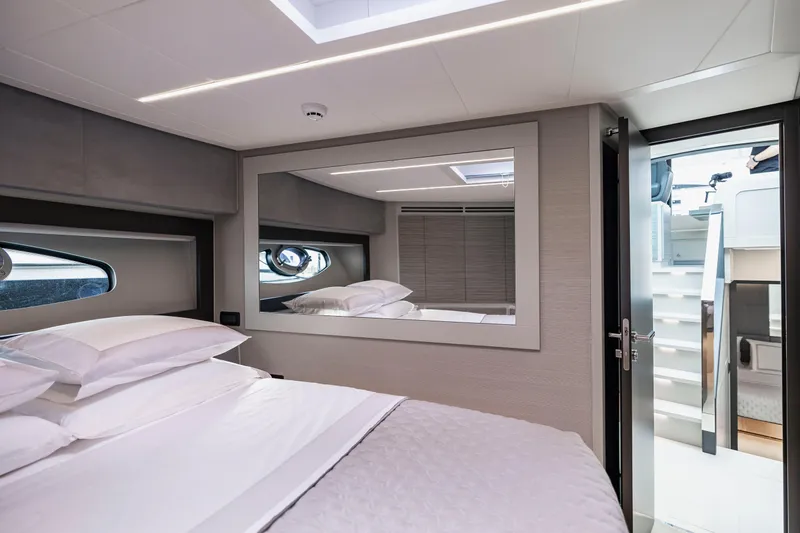 Sea Suite Yacht Photos Pics Luxurious bedroom interior of 2021 Pershing 62 yacht with modern design and large mirror.
