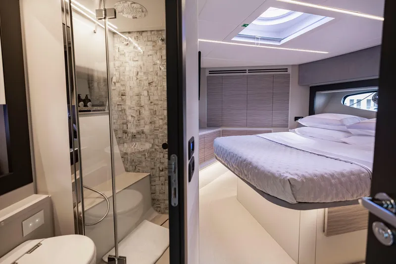 Sea Suite Yacht Photos Pics Luxurious interior of 2021 Pershing 62 yacht featuring bedroom and modern bathroom.