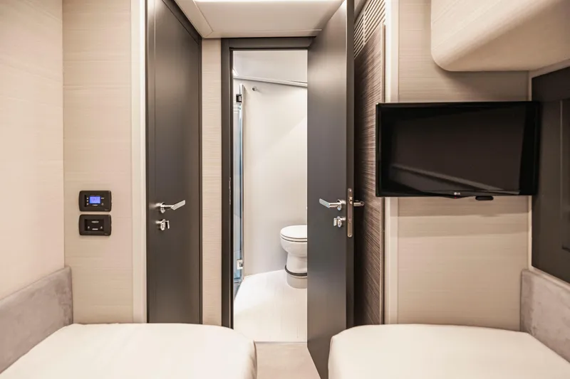 Sea Suite Yacht Photos Pics Interior of 2021 Pershing 62 yacht cabin with modern bathroom and TV.