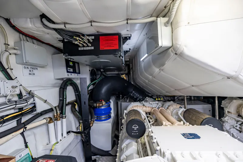 Sea Suite Yacht Photos Pics Engine room of a 2021 Pershing 62 yacht, showcasing mechanical components and wiring.