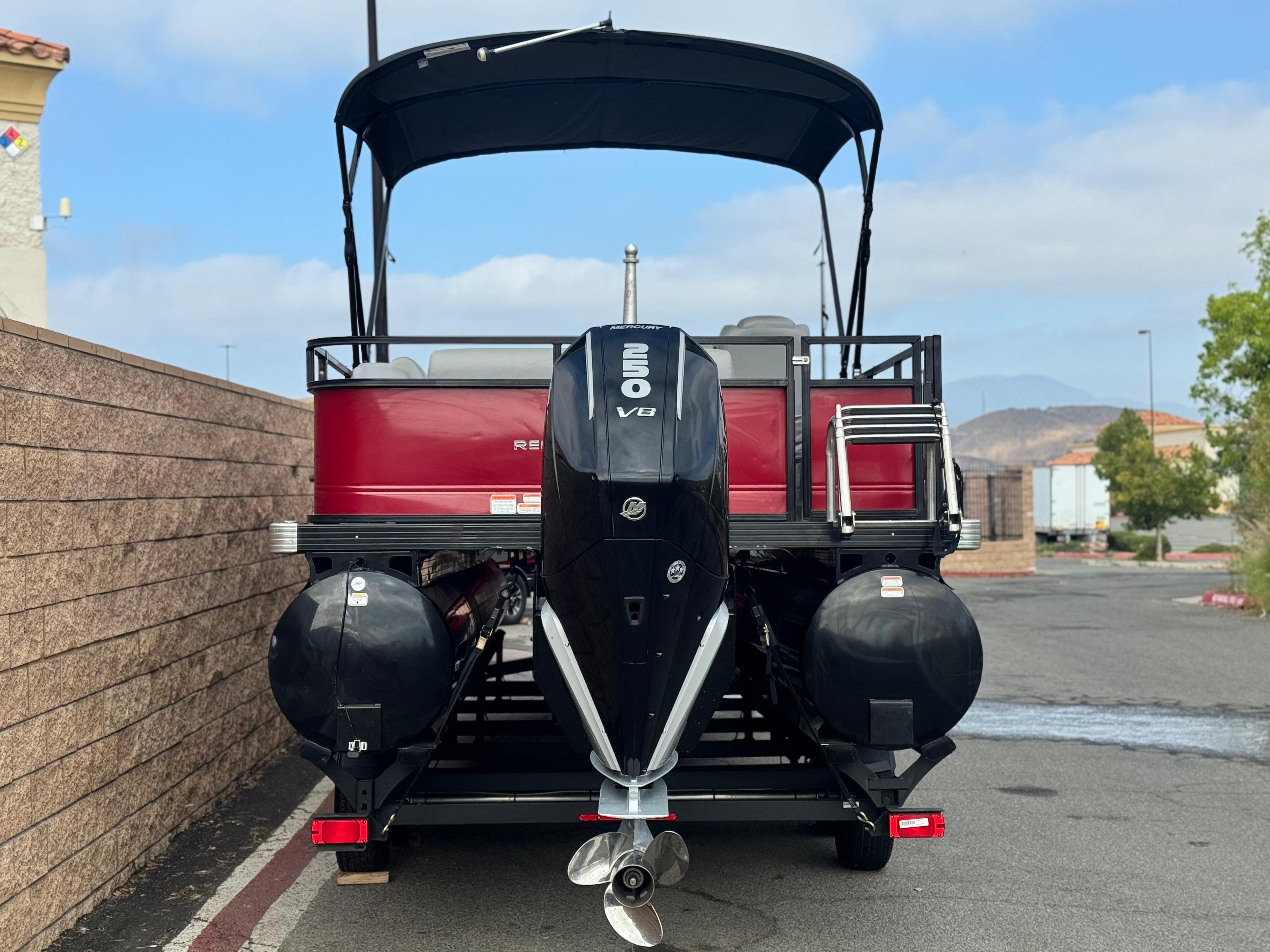 2023 Regency 250 DL3 pontoon boat with V8 engine, parked outdoors.