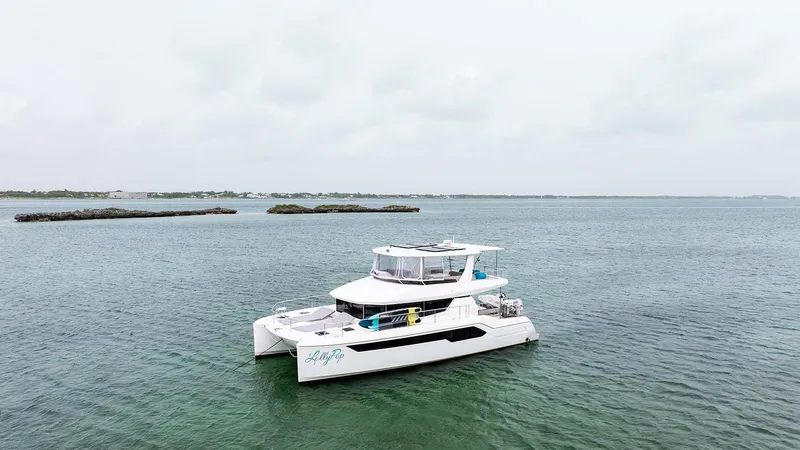 Lollypop Yacht Photos Pics 2022 Leopard 53 Powercat yacht on calm waters, overcast sky.