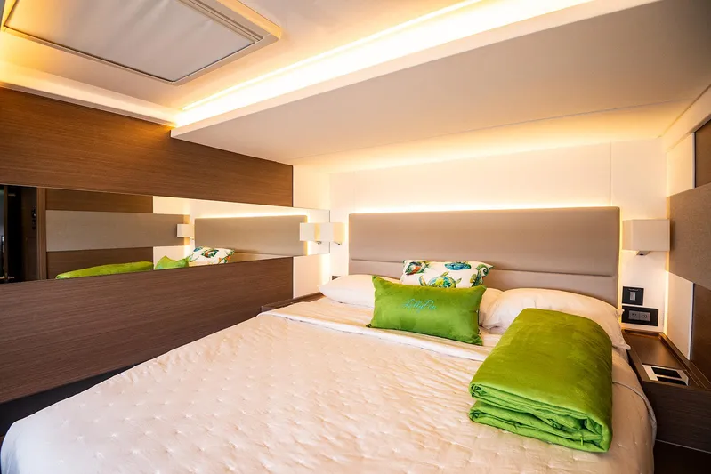 Lollypop Yacht Photos Pics Luxurious bedroom interior of 2022 Leopard 53 Powercat with modern design and green accents.