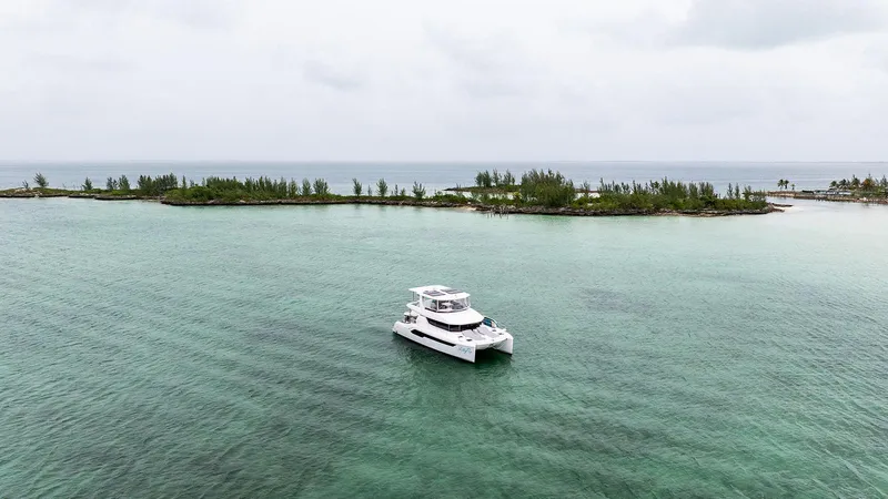 Lollypop Yacht Photos Pics 2022 Leopard 53 Powercat yacht on serene turquoise waters near lush island.