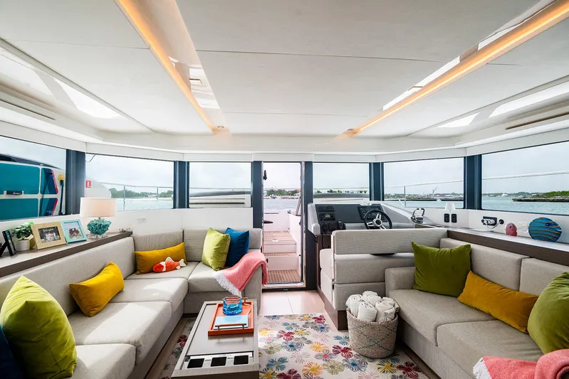 Lollypop Yacht Photos Pics Luxurious interior of 2022 Leopard 53 Powercat yacht with colorful cushions and panoramic windows.