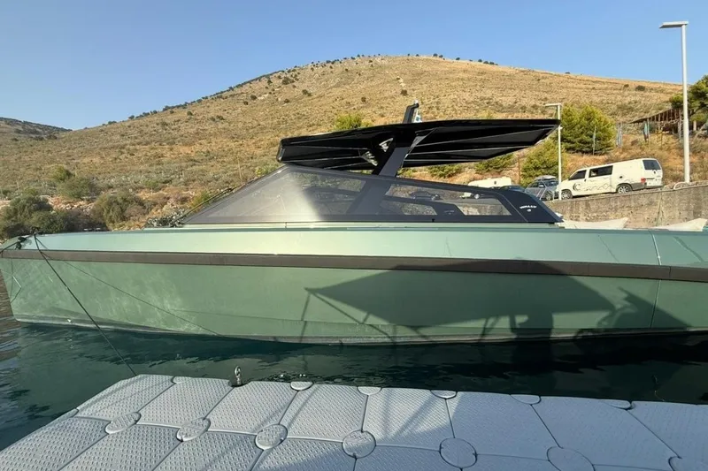  Yacht Photos Pics 2025 Wally Tender 43 yacht docked by a scenic hillside.