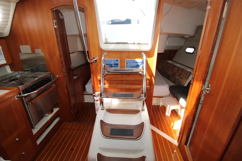 Medicinal Yacht Photos Pics Interior of 2002 Hunter 410 sailboat with wood finish and compact kitchen area.