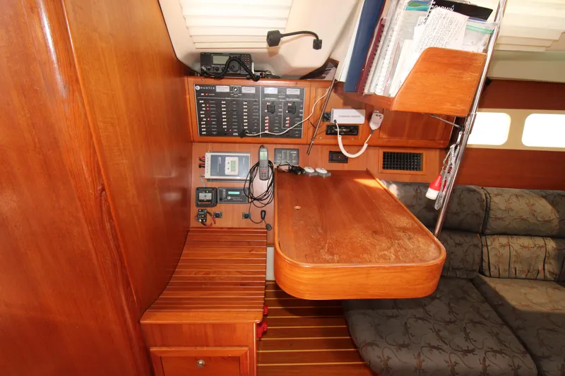 Medicinal Yacht Photos Pics Navigation station in 2002 Hunter 410 sailboat with control panels and seating area.