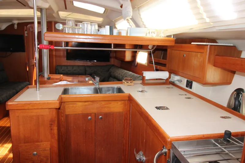 Medicinal Yacht Photos Pics Interior of 2002 Hunter 410 sailboat kitchen with wooden cabinetry and modern amenities.