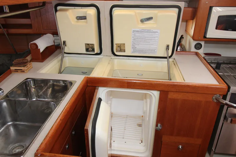 Medicinal Yacht Photos Pics Galley kitchen in 2002 Hunter 410 yacht with sink, fridge, and storage.