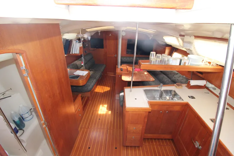 Medicinal Yacht Photos Pics Interior of 2002 Hunter 410 sailboat with wood finish, kitchen, and seating area.