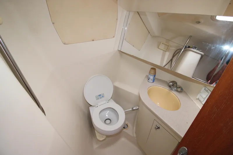 Medicinal Yacht Photos Pics Compact bathroom in 2002 Hunter 410 boat with toilet, sink, and mirror.