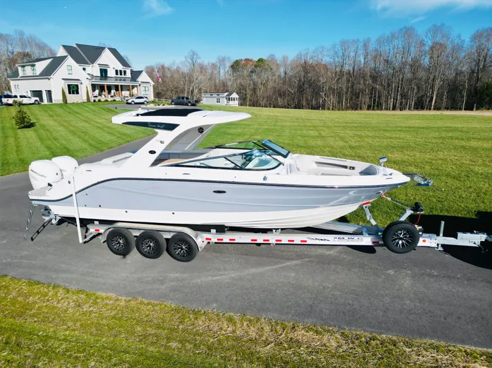 The Good Stuff Yacht Photos Pics 2023 Sea Ray SLX 310 OB boat on trailer, parked on driveway near house.