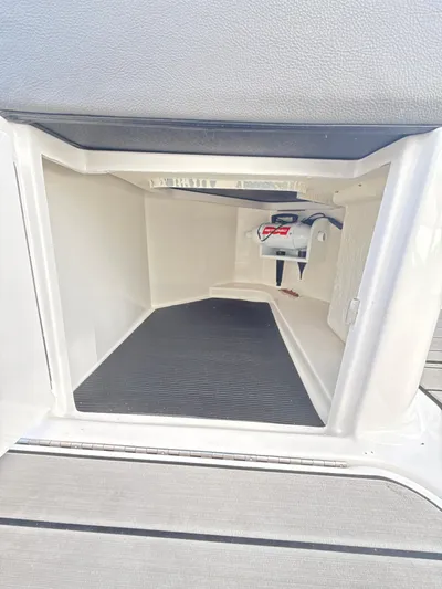 The Good Stuff Yacht Photos Pics 2023 Sea Ray SLX 310 OB storage compartment with black mat and battery switch.