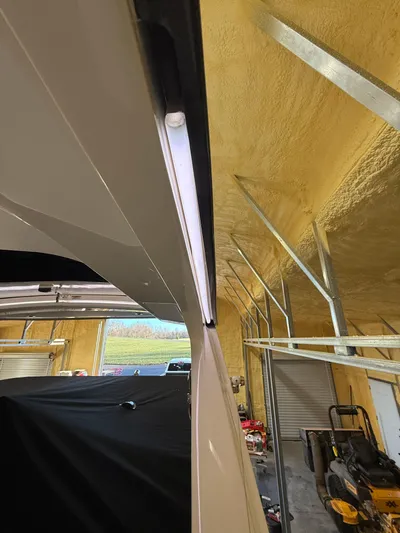 The Good Stuff Yacht Photos Pics 2023 Sea Ray SLX 310 OB in a garage, showcasing sleek design and lighting.