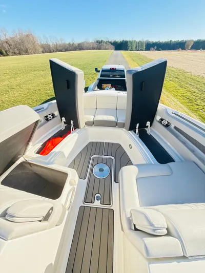 The Good Stuff Yacht Photos Pics 2023 Sea Ray SLX 310 OB boat interior with open storage compartments, parked on grass.