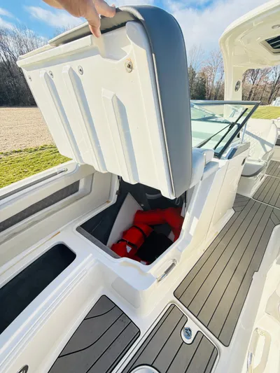 The Good Stuff Yacht Photos Pics 2023 Sea Ray SLX 310 OB boat with open storage compartment and life jackets.
