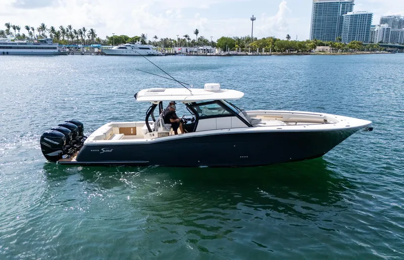  Yacht Photos Pics 2020 Scout 380 LXF boat cruising on water with cityscape background.