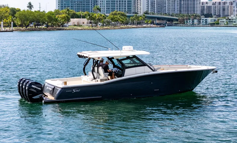  Yacht Photos Pics 2020 Scout 380 LXF boat cruising on water with cityscape background.