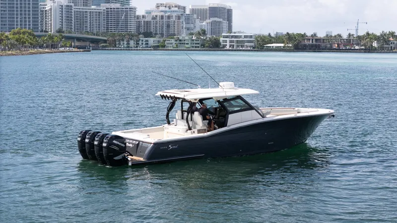  Yacht Photos Pics 2020 Scout 380 LXF boat cruising near city skyline.