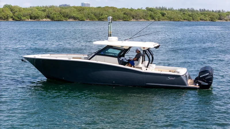  Yacht Photos Pics 2020 Scout 380 LXF boat on water, side view with lush greenery in background.