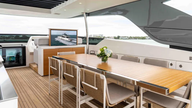 Honey Pot Yacht Photos Pics Luxury dining area on the 2019 Sanlorenzo SL 106 yacht with a wooden table and chairs.