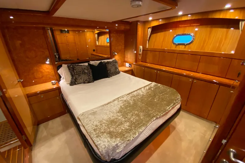  Yacht Photos Pics Luxurious bedroom interior of 2001 Compass 57 yacht with elegant wood finish and cozy bedding.