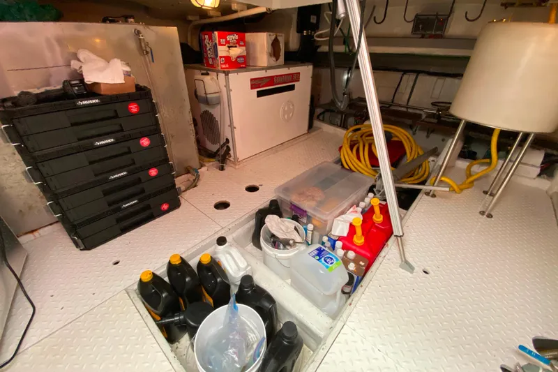  Yacht Photos Pics Engine room of 2001 Compass 57 yacht with tools, oil containers, and storage boxes.