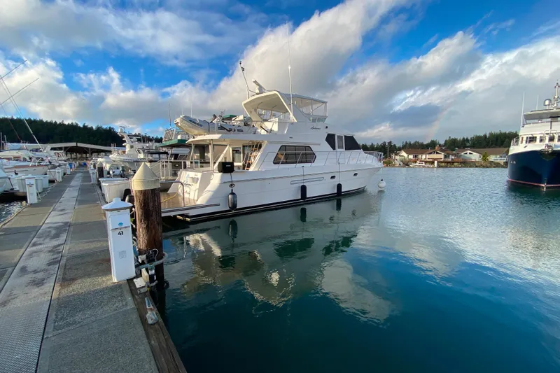  Yacht Photos Pics Compass 57 yacht from 2001 docked at a marina under a partly cloudy sky.