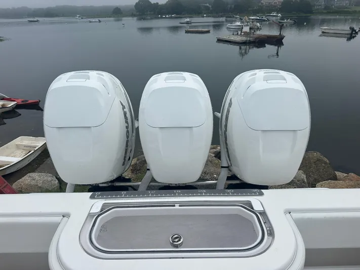Fly Girl Yacht Photos Pics Triple Mercury outboard engines on a 2020 Invincible 39 Open Fisherman boat by a calm lake.