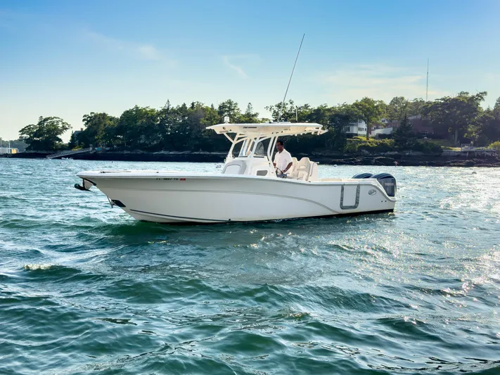 Lil Oa Yacht Photos Pics 2022 Sea Fox 288 Commander boat cruising on a sunny day near a wooded shoreline.