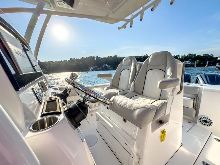 Lil Oa Yacht Photos Pics 2022 Sea Fox 288 Commander boat interior with luxurious seating and steering wheel, on a sunny day.
