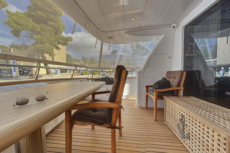  Yacht Photos Pics Luxurious Maiora 20 yacht deck with wooden furniture, sunglasses, and scenic view, 2002 model.