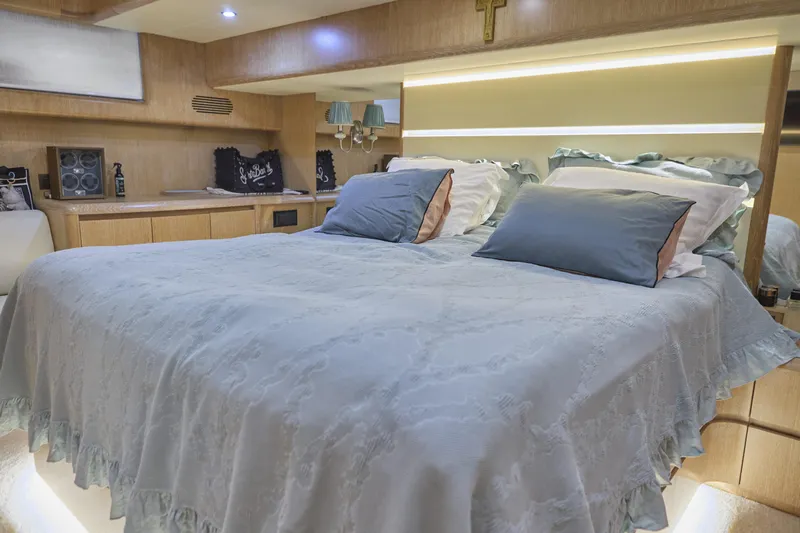  Yacht Photos Pics Luxurious bedroom interior of 2002 Maiora 20 yacht with elegant bedding and ambient lighting.