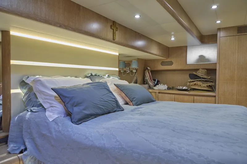 Yacht Photos Pics Luxurious bedroom interior of 2002 Maiora 20 yacht with elegant bedding and wooden accents.