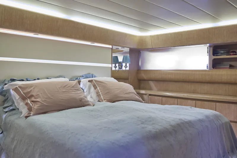  Yacht Photos Pics Luxurious bedroom interior of 2002 Maiora 20 yacht with elegant bedding and ambient lighting.