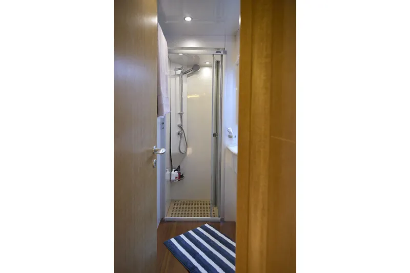  Yacht Photos Pics Shower area in 2002 Maiora 20 yacht with striped rug and modern fixtures.