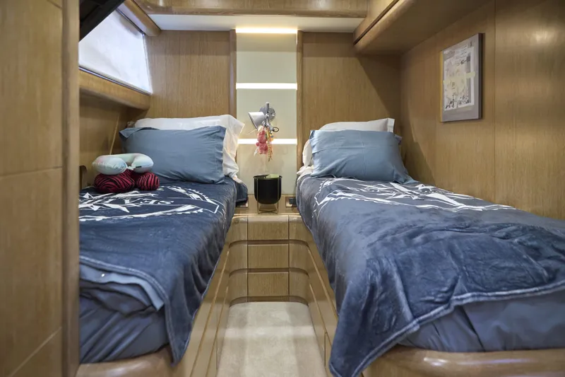  Yacht Photos Pics Luxurious twin cabin interior on a 2002 Maiora 20 yacht, featuring cozy bedding and elegant wood finishes.