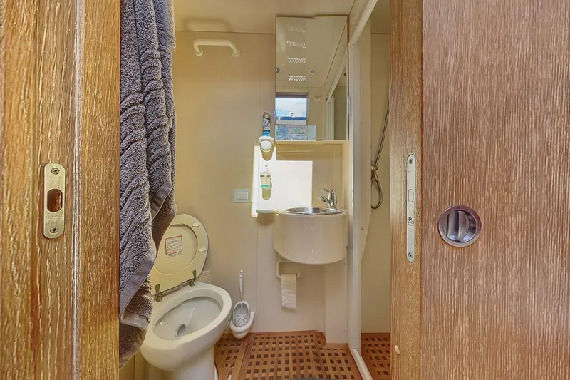  Yacht Photos Pics Compact bathroom on 2002 Maiora 20 yacht with toilet, sink, and towel.