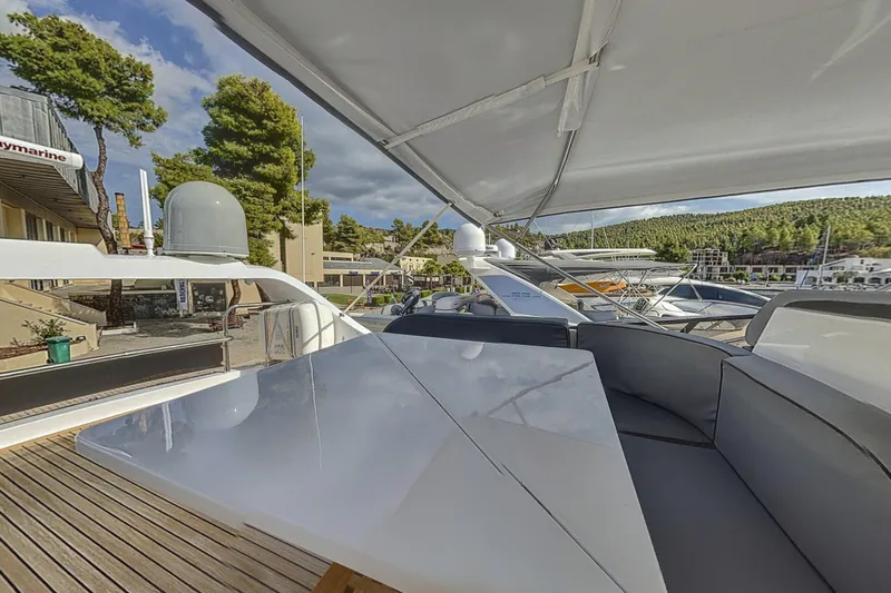  Yacht Photos Pics Luxurious 2002 Maiora 20 yacht deck with seating and canopy, docked in scenic marina.