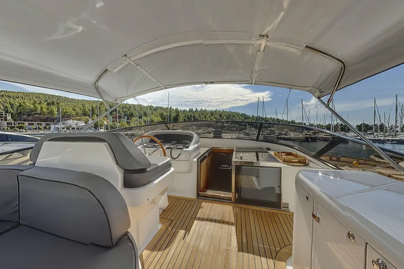  Yacht Photos Pics Luxurious 2002 Maiora 20 yacht interior with helm, marina view, and elegant wood flooring.