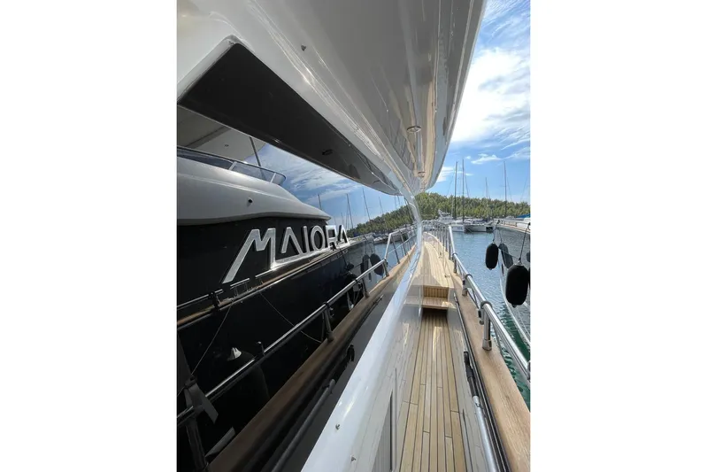  Yacht Photos Pics Luxurious 2002 Maiora 20 yacht docked, showcasing sleek design and wooden deck.