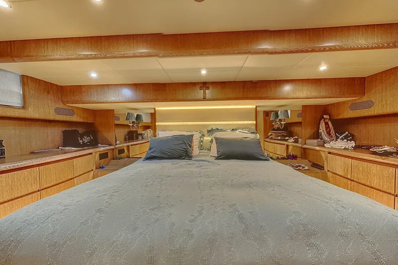  Yacht Photos Pics Luxurious bedroom interior of 2002 Maiora 20 yacht with wood paneling and ambient lighting.